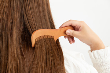 櫛で髪をとかす女性01