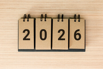 New Year 2026 is coming concept. The word 2026 on wooden background. Flat lay.