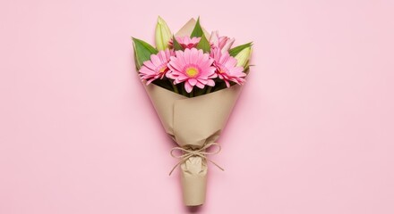 Schöner Blumenstrauß aus rosa Gerbera und Lilienknospen, von oben auf rosa Hintergrund.