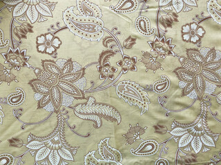 A close-up view of a Mughal floral butta in white and brown adorns the yellow cotton fabric.