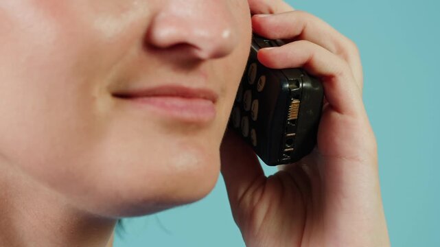 80s 90s retro vintage cell phone being used by a young adult woman, taking old mobile phone with antenna from jeans pocket.