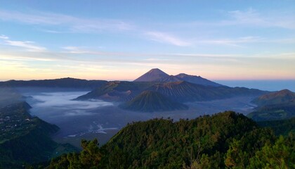 Stunning sunrise paints volcanic landscape with misty valleys and lush green hills below