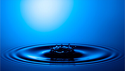 A captivating water drop creates concentric ripples on a serene blue surface, capturing a moment of impact with a minimalist aesthetic
