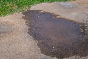 Puddle of water on the concrete floor. After rain and irrigation.
