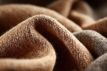 Warm brown woolen knit textile with cozy natural fibers and soft pleats surface