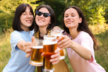 Group of happy friends having fun and drinking beer outdoors