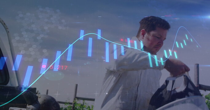 Reaching into dark duffle bag, field technician analyzing candlestick chart by machinery outdoors