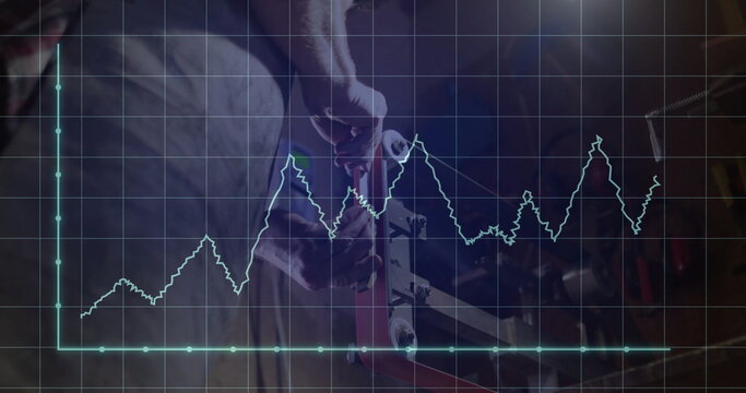 Mechanic wearing gloves and apron tightening vise bolt in workshop, line graph overlay, copy space