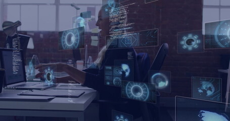 Pointing professional woman highlighting code on laptop in open-plan office, with holographic UIs