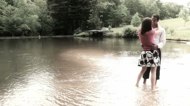 Mixed Couple Standing in Pond Slow Dancing Together