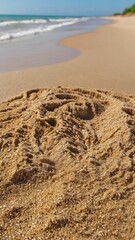 Obraz premium Footprints in the Sand A Serene Beachscape with Ocean Waves and Golden Sand