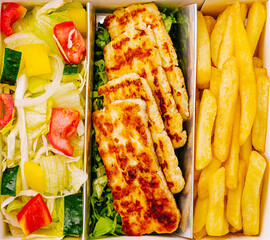 Delicious meal box with grilled cheese or chicken, fresh salad, and golden fries
