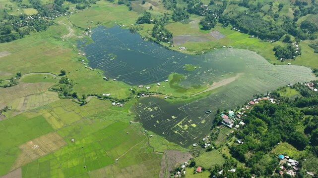 Lake Seloton with fish farm surrounded by agricultural landscape. Mountain with green forest. Lake Sebu. Mindanao, Philippines.