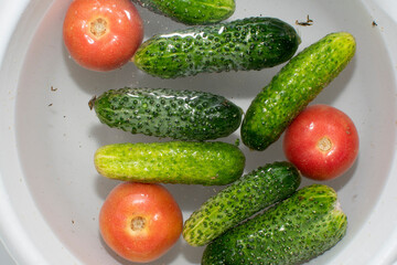 Close up view of cucumbers and tomatoes soaked in water	