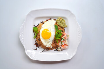Freshly Cooked Biriyani Rice with Golden Egg Omelet on White Plate.