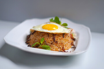 Tasty Biriyani Rice and Egg Omelet Meal Served on White Plate.