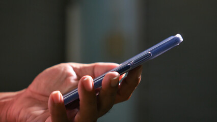 Smartphone in Hand: A close-up of a hand holding a sleek, modern smartphone. The image showcases the device, highlighting its design and the intimacy of digital interaction.