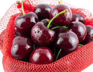 Mesh Bag of Cherries with Water Droplets, Angled Front View, Isolated