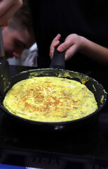 tortilla española de huevo y patatas friéndose en la sartén