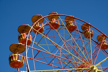 bright yellow-orange ferris wheel against blue sky