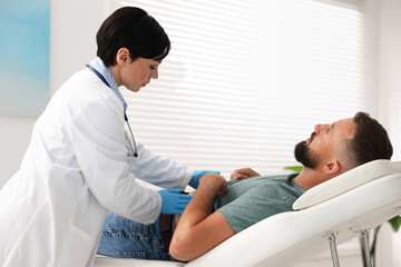 Fototapeta premium Gastroenterologist examining patient with stomach pain in clinic