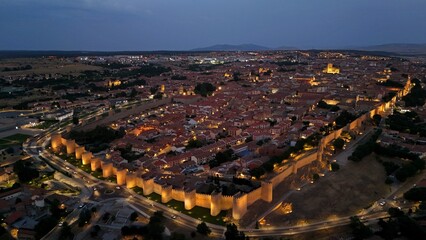 Panoramic aerial view of Ávila, dusk, lights, medieval wall, old town, monument, old town cathedral, right side sunset © Navacepe