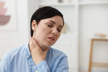 Woman suffering from sore throat at home. Space for text