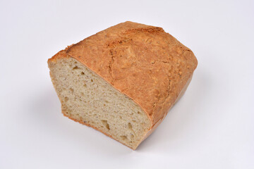 A freshly baked loaf of homemade bread, sliced in half, is presented on a clean white background