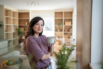 Woman enjoying morning coffee in modern apartment