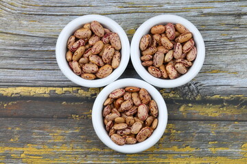 red kidney beans in wooden bowl isolated on dark background.