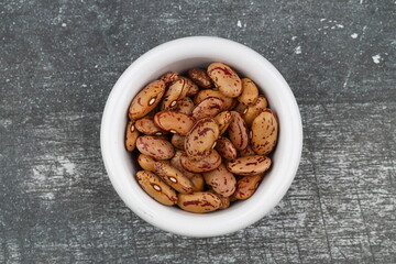 red kidney beans in wooden bowl isolated on dark background.