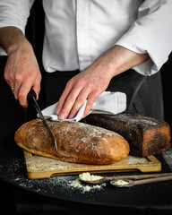 Carefully Cutting Artisan Bread Using a Chefs Expert Hands and