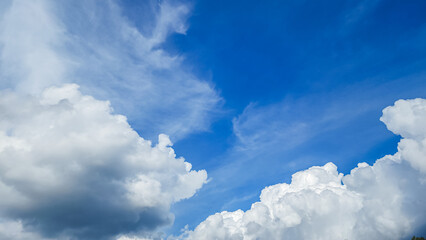 A serene view of a vibrant blue sky dotted with fluffy white clouds and wispy streaks, ideal for backgrounds in travel, wellness, and inspirational content.