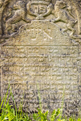 Historic old weathered stone slab with Hebrew writing at the public cemetery