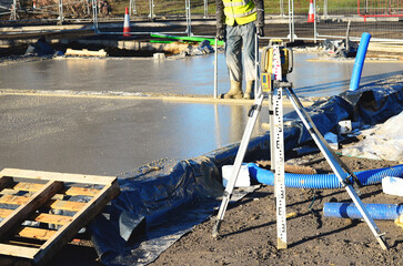 Workers are smoothing out a newly poured layer of concrete