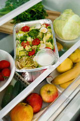 Takeaway healthy food in aluminum foil containers with vegetables and grains.