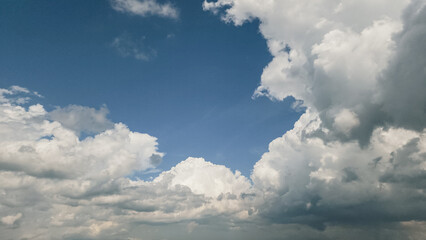 A breathtaking view of a bright blue sky filled with dramatic white clouds, perfect for backgrounds in travel, nature, and inspirational marketing campaigns