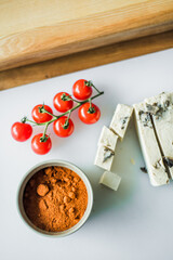Hands cutting cheese, vegetables and ingredients for healthy meals.