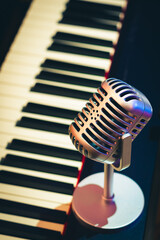 vintage condenser microphone on piano keys