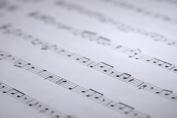 Sheet with musical notes as background, closeup
