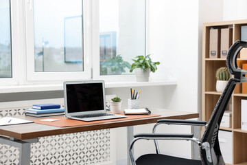 Stylish workplace with modern laptop and stationery on wooden desk indoors