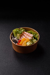 Bowl with shrimps, seafood, rice, oranges, tomatoes with sauce. Bowl with prawns