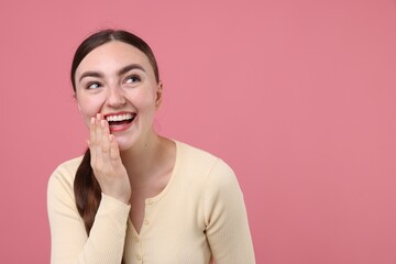 Beautiful woman laughing on pink background. Space for text