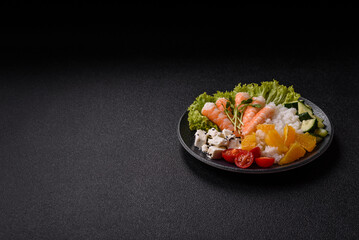 Bowl with shrimps, seafood, rice, oranges, tomatoes with sauce. Bowl with prawns