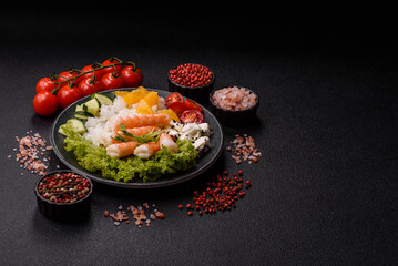 Bowl with shrimps, seafood, rice, oranges, tomatoes with sauce. Bowl with prawns