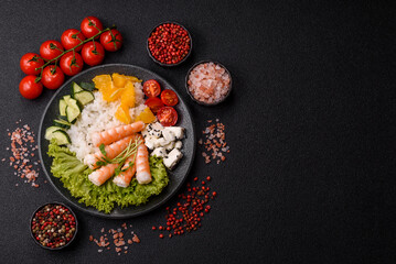 Bowl with shrimps, seafood, rice, oranges, tomatoes with sauce. Bowl with prawns