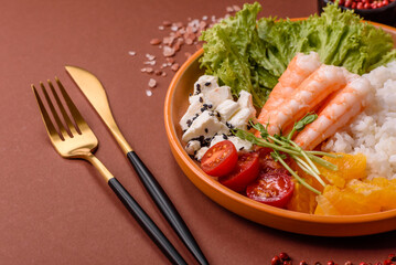 Bowl with shrimps, seafood, rice, oranges, tomatoes with sauce. Bowl with prawns