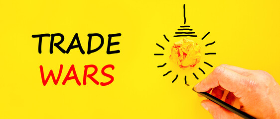Trade wars symbol. Concept word Trade wars on beautiful yellow paper. Businessman's hand. Light...