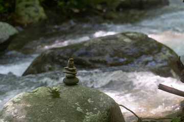 zen stones next to flowing water 