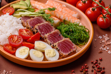 Seafood bowl, tuna tataki fillet slices with rice, oranges, tomatoes and sauce. Tuna bowl